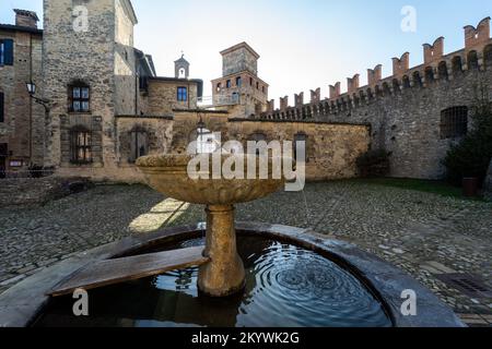 Das mittelalterliche Dorf und Schloss Vigoleno in den Apenninen in der Provinz Piacenza, Emilia Romagna, Norditalien - zentraler Platz mit Brunnen Stockfoto