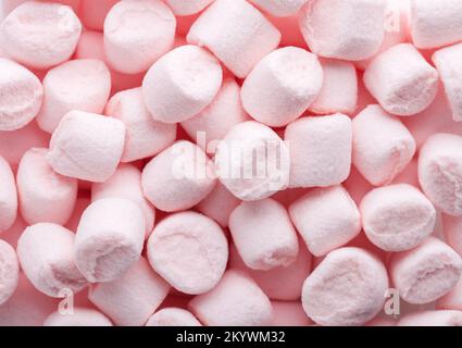 Mini-Marshmallows in hellrosa Farbe. Flach verlegt. Selektiver Fokus. Stockfoto