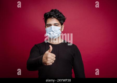 Junger indianer mit Maske und Daumen hoch Stockfoto