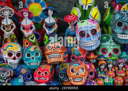 Farbenfrohe handbemalte Keramikschädel und La Catrinas für die Day of the Dead Fiesta zum Verkauf auf der Straße in Oaxaca, Mexiko. Stockfoto