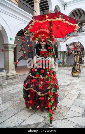 Eine Person auf Stelzen, verkleidet als La Catrina für einen Kostümwettbewerb zur Todestag-Feier in Oaxaca, Mexiko. Stockfoto