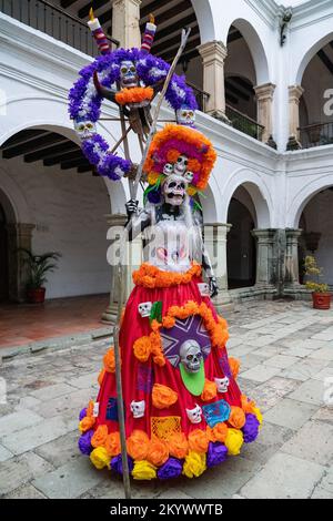 Eine Person auf Stelzen, verkleidet als La Catrina für einen Kostümwettbewerb zur Todestag-Feier in Oaxaca, Mexiko. Stockfoto