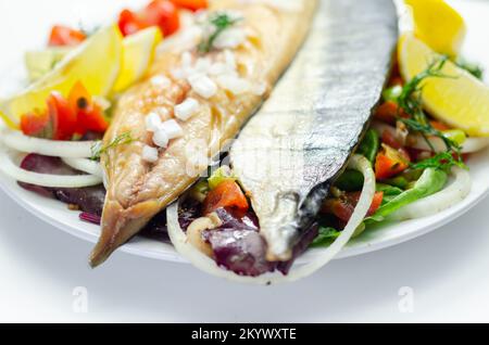 Heiße geräucherte schottische Makrelenfilets mit Zwiebeln, Tomaten und Salat, gesunde Ernährung Stockfoto