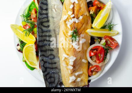 Heiße geräucherte schottische Makrelenfilets mit Zwiebeln, Tomaten und Salat, gesunde Ernährung Stockfoto