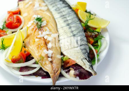 Heiße geräucherte schottische Makrelenfilets mit Zwiebeln, Tomaten und Salat, gesunde Ernährung Stockfoto