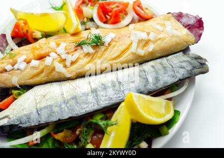 Heiße geräucherte schottische Makrelenfilets mit Zwiebeln, Tomaten und Salat, gesunde Ernährung Stockfoto