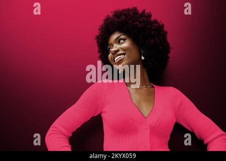 Glückliche junge afrikanische Frau mit Haaren. Farbe des Jahres 2023, Viva Magenta. Stockfoto