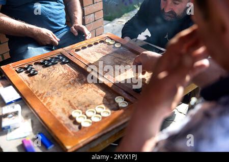 Einheimische Männer spielen beim Rauchen in einem Park in einem alten Kurort Tskaltubo in der Nähe von Kutaisi in Georgia Stockfoto