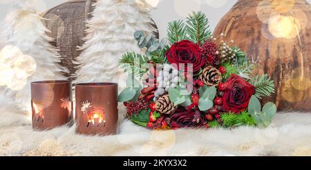 Weihnachtliches Stillleben mit Blumenstrauß, Kerzen und Dekorationen. Stockfoto