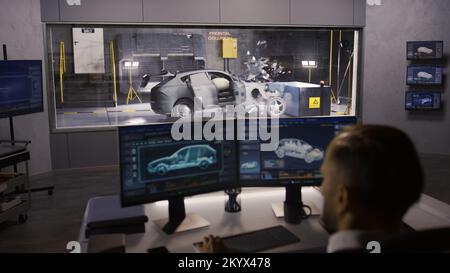 Ein Ingenieur in einem Crashtest-Labor simuliert einen Verkehrsunfall mit einem Crashtest-System, um die Sicherheitsparameter eines umweltfreundlichen, hochmodernen Elektrofahrzeugs zu ermitteln, das gerade entwickelt wird. Stockfoto