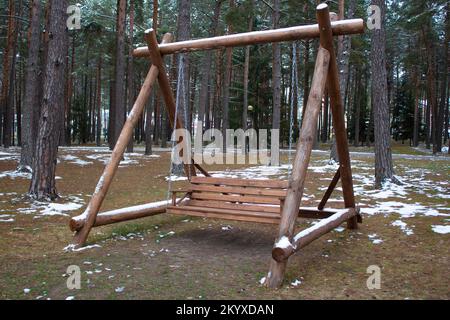 Leerer Holzschaukel auf Ketten in einem ruhigen Park, Winterfrost Tag Stockfoto