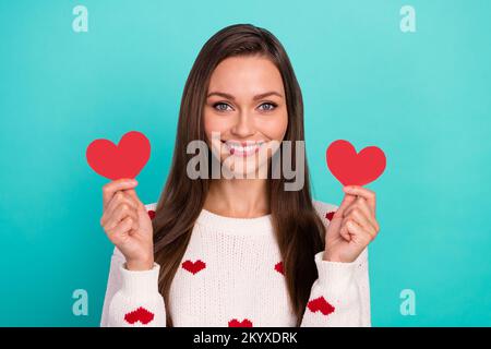 Foto einer fröhlichen, niedlichen Person, lächelnde Hände halten kleine Herzsymbole isoliert auf smaragdfarbenem Hintergrund Stockfoto