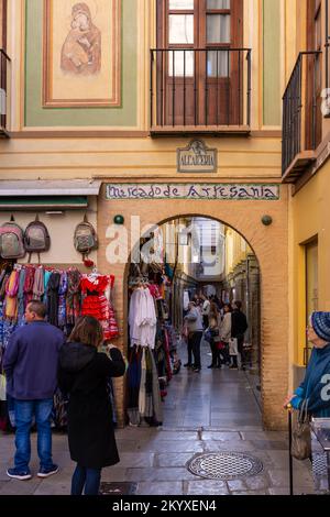 Granada, Spanien; November bis 27. November 2022: „Handwerksmarkt“ Alcaicería de Granada, enge Straße mit maurischen Basaren für Kleidung und Kunsthandwerk Stockfoto