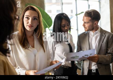 Gruppe von Geschäftsleuten, die eine Präsentation von Geschäftsdaten im Büro beobachten. Business People Meeting-Konzept Stockfoto