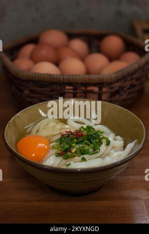 Mishima udon ist exquisit in ihrer Einfachheit. Serviert wird warm oder kalt, nur mit Sojasoße, grünen Zwiebeln, einem Hauch Chili und frischen Eiern beim Kunden Stockfoto