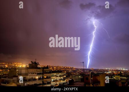 Stadtblick bei Nacht unter Gewitter mit Blitzschlag. Starker Blitz während eines Gewitters in der Stadt. Wolke an Erde, elektrischer Blitz Stockfoto