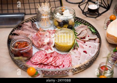 Wurstscheiben, Fleisch-Aorti, Prosciutto und Speck mit Senfsauce, Dose mit sonnengetrockneten Tomaten, Dose mit Oliven und Oliven Stockfoto