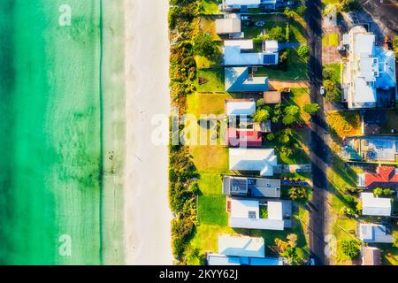 Smaragdglatte Wellen am weißen Sandstrand mit atemberaubendem Blick von oben auf das Ufer des Callala Beach Resort Town in der Jervis Bay von Australien. Stockfoto