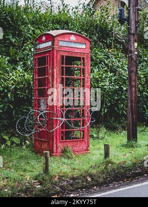 Rasierdraht um eine klassische rote Telefonzelle Stockfoto