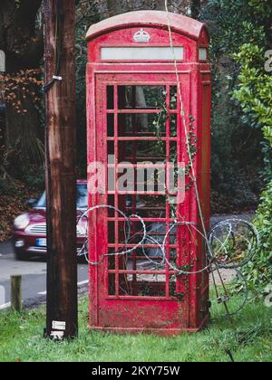 Rasierdraht um eine klassische rote Telefonzelle Stockfoto