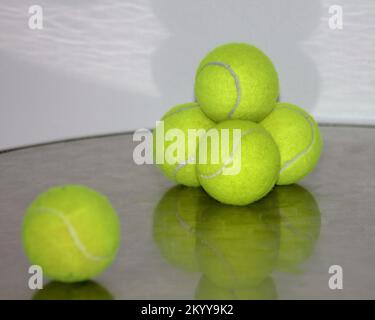 Drei Tennisbälle auf einem Metalltisch Stockfoto