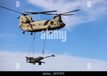 CH-47 Chinook von der 25. Combat Aviation Brigade trägt einen M777 Howitzer von der 25. Infanteriedivision Artillerie (DIVARTY) im Pohakuloa Training Area in Hawaii. Stockfoto