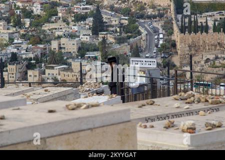 Ein männlicher chassidischer Jude, der seine Hingabe in einem Grab auf dem Ölberg in der historischen Stadt Jerusalem in Israel verrichtet Stockfoto