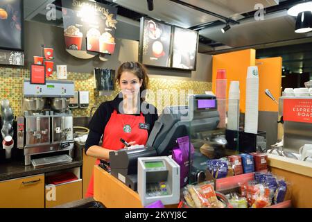 GENF, SCHWEIZ - 18. NOVEMBER 2015: Barista im Starbucks Café. Die Starbucks Corporation ist ein amerikanisches globales Kaffeeunternehmen und die Kaffeehauskette B. Stockfoto