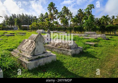 Alte verwitterte Grabsteine auf einem kleinen Friedhof, einer von vielen auf der tropischen Insel Rarotonga, Cook Islands Stockfoto