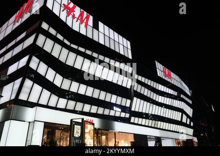 Peking, China-September 14. 2022: Großer H&M-Bekleidungsladen in Taikoo Li Sanlitun bei Nacht. Schnelle Modemarke Stockfoto