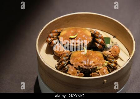 Zwei gedämpfte Krabben im Dampfgarer auf dem Tisch. Chinesisches Essen Stockfoto