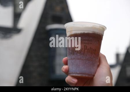 Peking, China-September 13. 2022: Nahhand mit einer Tasse Butterbier. In der Zauberwelt von Harry Potter in den Universal Studios Beijing Stockfoto