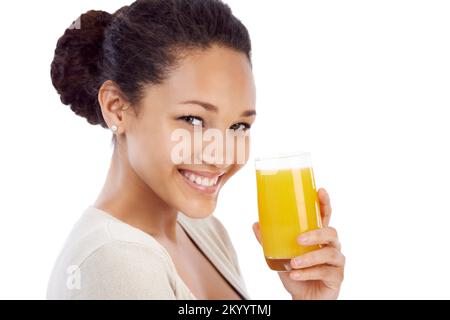 Sie bekommt ihre tägliche Dosis Vitamin C. eine junge Frau lächelt, während sie ein Glas Orangensaft trinkt. Stockfoto