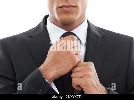 Er ist bereit... Bild eines Geschäftsmannes, der seine Krawatte vor weißem Hintergrund fixiert. Stockfoto