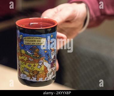 Köln, Deutschland. 02.. Dezember 2022. Eine Tasse Glühwein wird auf dem Weihnachtsmarkt im Kölner Dom serviert. An vielen Orten in Nordrhein-Westfalen sind die Weihnachtsmärkte genauso belebt wie vor der Corona-Pandemie. Zahlreiche Touristen reisen dieses Jahr wieder für dieses besondere Erlebnis. (Zu dpa: „Sehnsucht und Gemütlichkeit: Weihnachtsmärkte wie vor Corona“) Kredit: Sascha Thelen/dpa/Alamy Live News Stockfoto