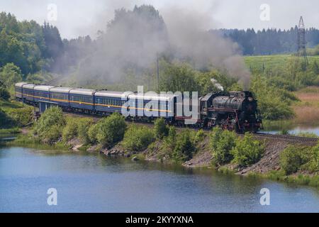 HELYULYA, RUSSLAND - 11. JUNI 2022: Touristenzug „Ruskeala Express“ fährt am Nachmittag des Juni zum Ruskeala Mountain Park Stockfoto