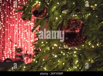 Köln, Deutschland. 02.. Dezember 2022. Eine Weihnachtskugel hängt im beleuchteten Baum auf dem Weihnachtsmarkt am Kölner Dom. An vielen Orten in Nordrhein-Westfalen sind die Weihnachtsmärkte genauso belebt wie vor der Corona-Pandemie. Zahlreiche Touristen reisen dieses Jahr wieder für dieses besondere Erlebnis. (Zu dpa: „Sehnsucht und Gemütlichkeit: Weihnachtsmärkte wie vor Corona“) Kredit: Sascha Thelen/dpa/Alamy Live News Stockfoto