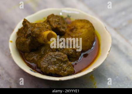 Hammelcurry und Kartoffeln, serviert in einer Schüssel. Das Gericht wird im traditionellen indischen Stil zubereitet. Würzige rote Soße und Kartoffeln werden begleitet. Foto mit Sele Stockfoto