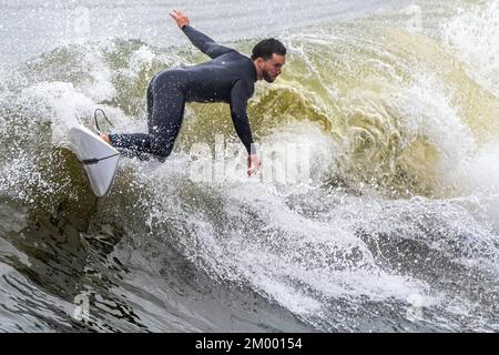 Surfer im Spätherbst in der Nähe des Jacksonville Beach Pier in Jacksonville Beach, Florida. (USA) Stockfoto