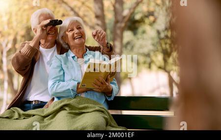 Liebe, Seniorenpaar und Vögel beobachten mit Buch, Fernglas und Romantik zusammen. Romantik, reifer Mann und ältere Frau in der Natur, glücklich und sprechend Stockfoto