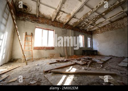 Ein verlassenes Lagerhaus, das von Menschen und Zeit zerstört wurde, ein zerstörtes Industriegebäude. Stockfoto