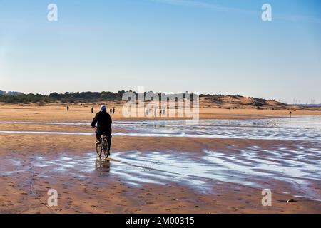 Lokaler Radfahrer und Wanderer am Strand, Plage Taghart, Küste, Essaouira, Marokko, Afrika Stockfoto