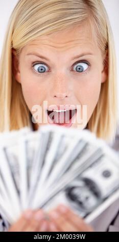 Das ist so viel. Eine aufgeregte junge Frau, die ihr Geld mit breiten Augen ansieht. Stockfoto