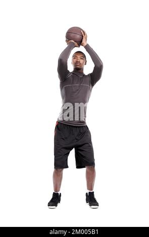 Ich schieße. Ein attraktiver junger Basketballspieler, der im Studio steht. Stockfoto