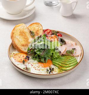 Frühstück mit Spiegeleiern mit Salat und Avocado Stockfoto