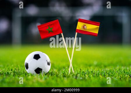 Marokko – Spanien – achtes Finale, letztes 16. Fußballspiel. Runde 16. Handgemachte Nationalflaggen und Fußball auf grünem Gras. Fußballstadion im Backgrou Stockfoto