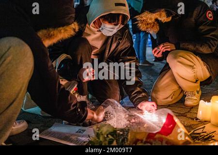 Boston, Usa. 02.. Dezember 2022. Demonstranten zünden Kerzen während einer Kerzenlichtwache für die tragischen Brandopfer der Urumqi im Tiananmen Memorial an. Mehr als 400 Menschen nehmen an einer Nachtwache bei Kerzenschein am Tiananmen Memorial in Boston Chinatown Teil, um gegen Chinas Null-Covid-Politik zu protestieren und den Opfern des tragischen Feuers von Urumqi am 2. Dezember 2022 zu gedenken. (Foto: Tang Ka Huen/SOPA Images/Sipa USA) Guthaben: SIPA USA/Alamy Live News Stockfoto