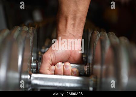 Bleibt der Lebensdauer beim Gewichtheben treu. Zugeschnittenes Bild eines Mannes, der eine Kurzhantel hebt. Stockfoto