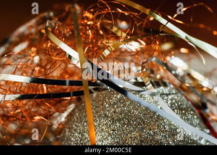 Glitzernde metallische Weihnachtsfäden auf der Oberfläche des weihnachtsballs, Nahaufnahme. Stockfoto