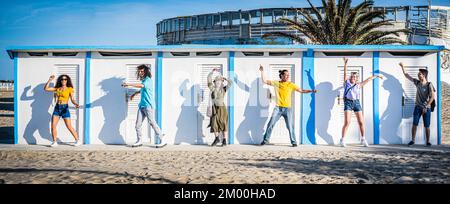Sechs verschiedene Leute tanzen vor der Strandhütte, Reise Sommerkonzept Stockfoto